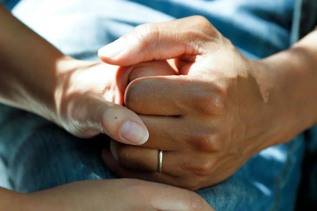 Caring hands holding a patient's hand